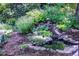 This home features a backyard pond and water feature surrounded by beautiful garden and rock detail at 1661 Oneida St, Denver, CO 80220