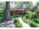 This home features a paved backyard with greenery, walkway, patio with hanging swing, and barbecue at 1661 Oneida St, Denver, CO 80220