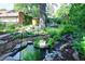 This home features a lush backyard with a tranquil pond, rock features, and beautiful garden space at 1661 Oneida St, Denver, CO 80220