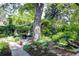 This home features a backyard entertaining area with chairs, fire pit, mature tree, and lush landscaping at 1661 Oneida St, Denver, CO 80220