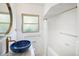 Modern bathroom featuring a unique blue vessel sink, stylish fixtures, and a shower/tub combo at 1661 Oneida St, Denver, CO 80220