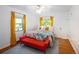 Inviting bedroom with two windows, wood floors, colorful bedding and a red bench at 1661 Oneida St, Denver, CO 80220