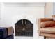 Close-up of a classic white fireplace with decorative molding and a protective screen at 1661 Oneida St, Denver, CO 80220