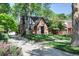Brick home with driveway and mature trees, offering a welcoming and established setting at 1661 Oneida St, Denver, CO 80220