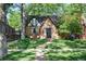 Charming brick home featuring a well-manicured lawn and mature trees for added curb appeal at 1661 Oneida St, Denver, CO 80220