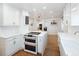 Updated kitchen with an island, white cabinets, stainless steel appliances and hardwood floors at 1661 Oneida St, Denver, CO 80220