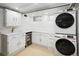 Well-organized laundry room with modern appliances and white cabinetry at 1661 Oneida St, Denver, CO 80220