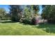 Spacious backyard with lush green grass and shrubbery offering a serene outdoor retreat at 1115 W Quincy Ave, Englewood, CO 80110