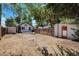 View of the backyard, with a wooden fence and detached shed and a small house in the background at 1115 W Quincy Ave, Englewood, CO 80110