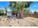 Backyard space with a mature shade tree and a woodpile, enhanced by a wooden fence at 1115 W Quincy Ave, Englewood, CO 80110