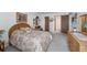 Bright bedroom with a floral-patterned bedspread, soft lighting, and multiple doorways at 13902 E Marina Dr # 303, Aurora, CO 80014