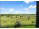 Picture window view of lush green fields dotted with trees against a clear blue sky with scattered clouds at 13902 E Marina Dr # 303, Aurora, CO 80014