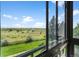 Enjoy this window view of a green open area with a backdrop of mature trees and sunny skies at 13902 E Marina Dr # 303, Aurora, CO 80014
