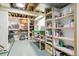 Spacious basement with unfinished ceiling, tile floor, and shelving storage at 7681 S Jellison St, Littleton, CO 80127