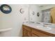 Well-lit bathroom featuring a large mirror, wood vanity, and adjacent toilet at 7681 S Jellison St, Littleton, CO 80127
