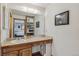 Bathroom with wood cabinets, large mirror, and open access to the bedroom at 7681 S Jellison St, Littleton, CO 80127