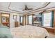 Spacious bedroom featuring a ceiling fan, large windows, and an adjacent bathroom at 7681 S Jellison St, Littleton, CO 80127
