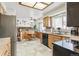 Open kitchen area featuring wood cabinets, tile floors, and stainless steel appliances with natural light at 7681 S Jellison St, Littleton, CO 80127