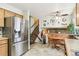 Spacious eat-in kitchen with stainless steel refrigerator, stairs and adjacent dining area at 7681 S Jellison St, Littleton, CO 80127