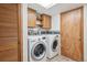 Well-equipped laundry room with modern washer and dryer and a cabinet at 7681 S Jellison St, Littleton, CO 80127