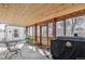 Cozy sunroom with wood paneled ceiling, tile floor, and sliding glass doors to backyard at 7681 S Jellison St, Littleton, CO 80127