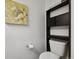 Compact half bath with a toilet and storage shelving unit at 20888 E 51St Pl, Denver, CO 80249