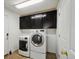 Functional laundry room with modern washer and dryer and ample storage cabinets at 20888 E 51St Pl, Denver, CO 80249