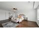 Bright main bedroom features dark wood floor, a ceiling fan, a stylish bed, and a sitting area at 20888 E 51St Pl, Denver, CO 80249