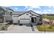Beautifully designed home featuring a three car garage, stone accents, and manicured lawn at 16218 E 111Th Pl, Commerce City, CO 80022