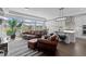 Inviting living room with a kitchen, large windows, hardwood floors, and comfortable leather furniture at 16218 E 111Th Pl, Commerce City, CO 80022