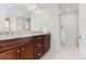 Bathroom with double sink vanity, dark wood cabinets, granite countertop, and walk-in shower at 2034 Newton St, Denver, CO 80211