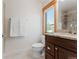 Well-lit bathroom featuring a granite countertop, wood-framed window, and tiled shower at 2034 Newton St, Denver, CO 80211