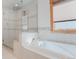 Bright bathroom showcasing a tiled shower, tub, and window with natural light at 2034 Newton St, Denver, CO 80211