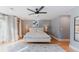 Light-filled bedroom with wood floors, white bedding, soft gray walls, and ceiling fan at 2034 Newton St, Denver, CO 80211