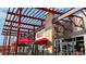 Rupert's restaurant featuring covered patio seating with red umbrellas and a view of the modern building at 2034 Newton St, Denver, CO 80211