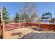 Home's backyard deck has wooden flooring and a red lattice border at 15099 E Wagontrail Pl, Aurora, CO 80015
