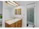 Clean bathroom with a single sink vanity, lighted mirror, cabinets, and glass shower at 15099 E Wagontrail Pl, Aurora, CO 80015