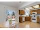 Functional kitchen with wooden cabinets, white appliances, and an eat-in area with a deck view at 15099 E Wagontrail Pl, Aurora, CO 80015