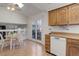 Functional kitchen with wooden cabinets, white appliances, and an eat-in area adjacent to an open floorplan at 15099 E Wagontrail Pl, Aurora, CO 80015