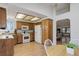 Functional kitchen with wooden cabinets, white appliances, and an eat-in area adjacent to an open floorplan at 15099 E Wagontrail Pl, Aurora, CO 80015