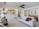 Bright living room featuring a wet bar, a ceiling fan, and views of the adjacent dining room and staircase at 15099 E Wagontrail Pl, Aurora, CO 80015