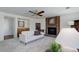 Comfortable living room with a brick fireplace, wet bar, ceiling fan, and neutral carpet at 15099 E Wagontrail Pl, Aurora, CO 80015