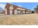 Exterior view of the building featuring brickwork, balconies and a grassy front lawn at 10211 Ura Ln # 10-105, Thornton, CO 80260