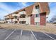 Exterior view of the building featuring brickwork, balconies and a parking lot at 10211 Ura Ln # 10-105, Thornton, CO 80260