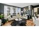 Inviting living room featuring dark walls, wood floors, and bright natural light from the large windows at 10211 Ura Ln # 10-105, Thornton, CO 80260