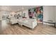 Open living space with wood floors, white sectional, and a combined living/kitchen area at 11132 Via Lata Dr, Broomfield, CO 80020