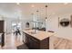 Open-concept kitchen with island seating and a view of the dining and living area at 1420 E Witherspoon Dr, Elizabeth, CO 80107
