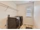 Well-lit laundry room featuring modern front-loading washer and dryer with wooden-style flooring at 1420 E Witherspoon Dr, Elizabeth, CO 80107