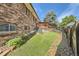 Landscaped backyard with brick retaining wall and wooden fence at 13627 W Alaska Dr, Lakewood, CO 80228