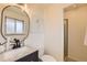 Updated bathroom with a modern vanity, round mirror, and walk-in shower at 13627 W Alaska Dr, Lakewood, CO 80228